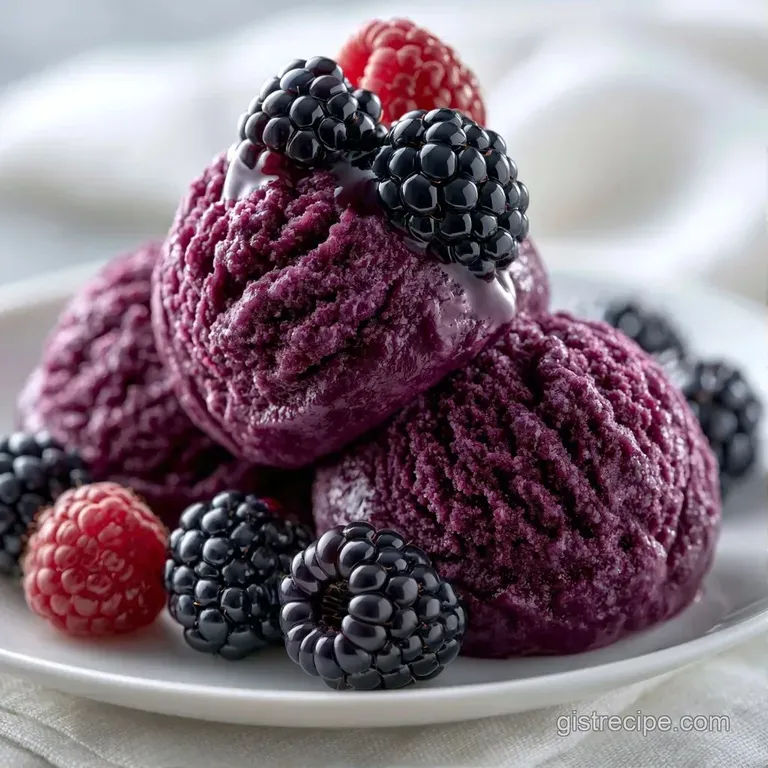 Dark purple frozen cream swirls on a white plate, garnished with a fresh berry and a tiny mint leaf.