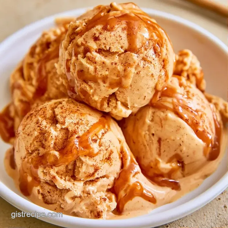 Pale gold ice cream scoops in a chilled glass bowl, drizzled with glossy caramel sauce and a cinnamon stick.