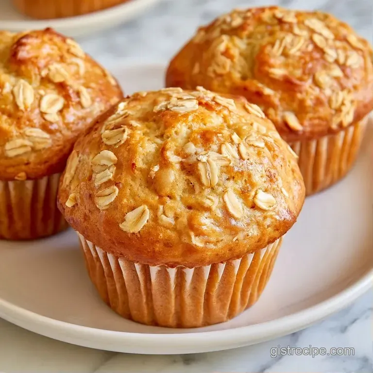 Three golden-brown muffins stacked on a white ceramic plate beside a small bowl of honey and fresh blueberries.
