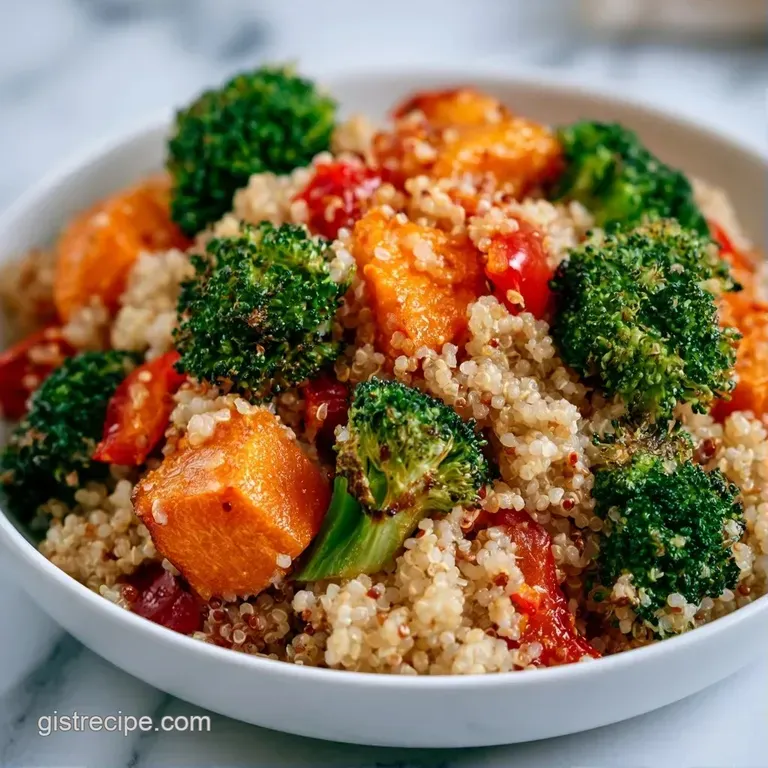 A neat arrangement of fluffy quinoa, sliced avocado, and roasted chickpeas in a matte ceramic bowl with a lime wedge.