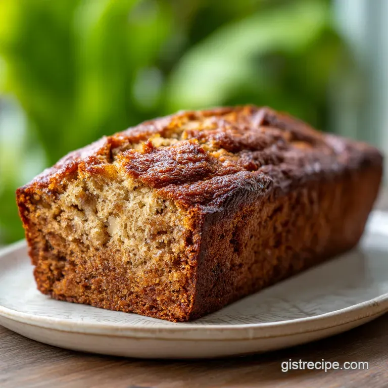 A thick slice of banana bread, glistening with moisture. Served on a white plate with a smear of creamy butter. Comforting...