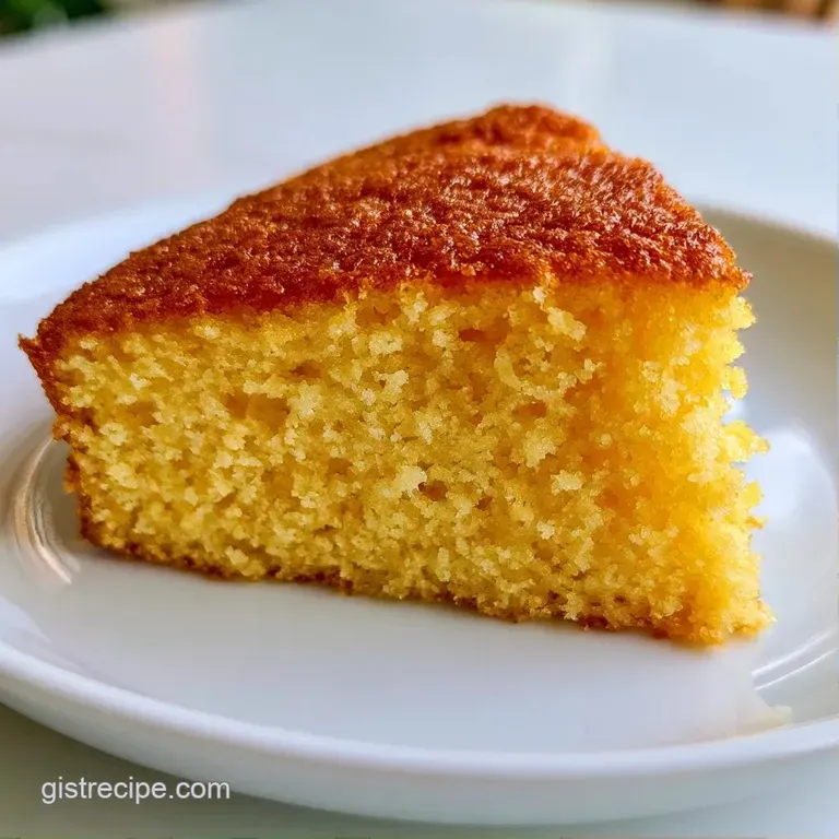 Elegant slice of pale yellow cake with fluffy layers and smooth white icing on a minimalist porcelain plate.