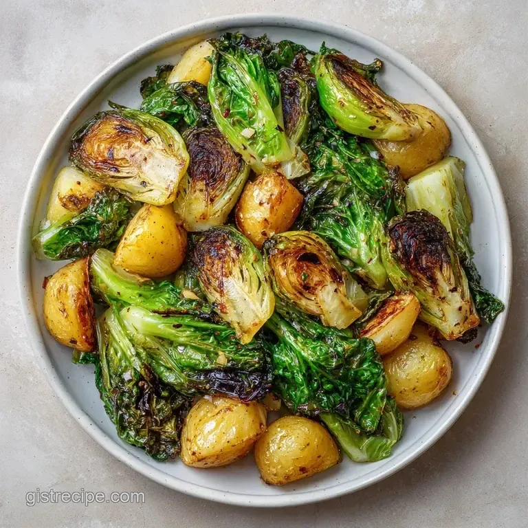 Charred cabbage wedges and crisp potato cubes arranged on a white ceramic plate with a drizzle of herb oil.